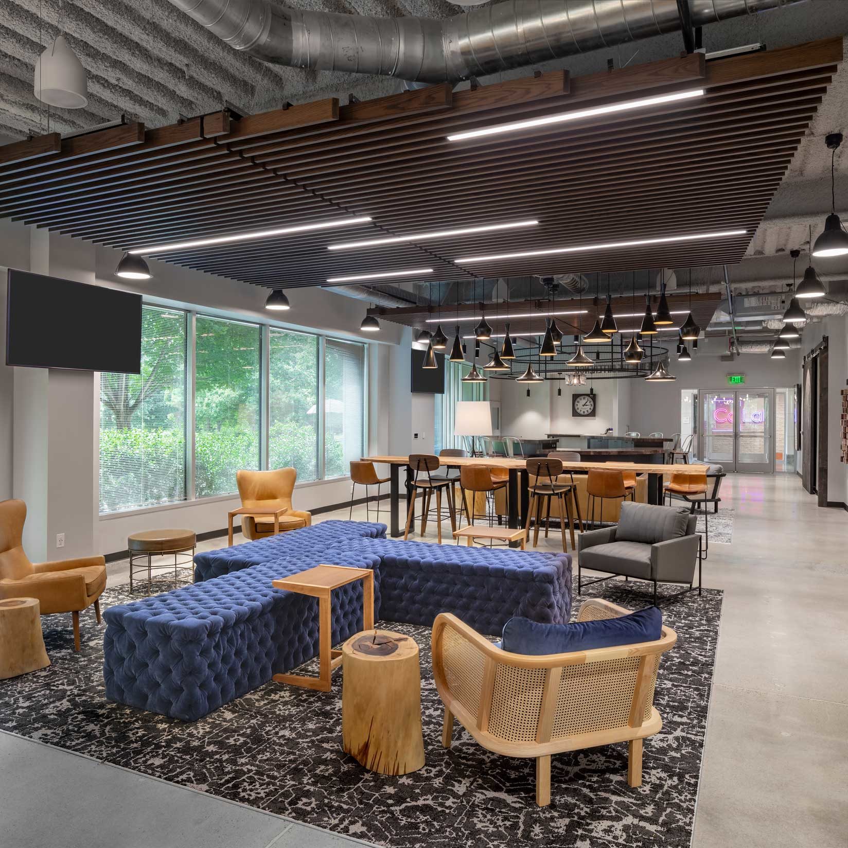 Various types of pendant lighting and acoustic paneling in an open office space