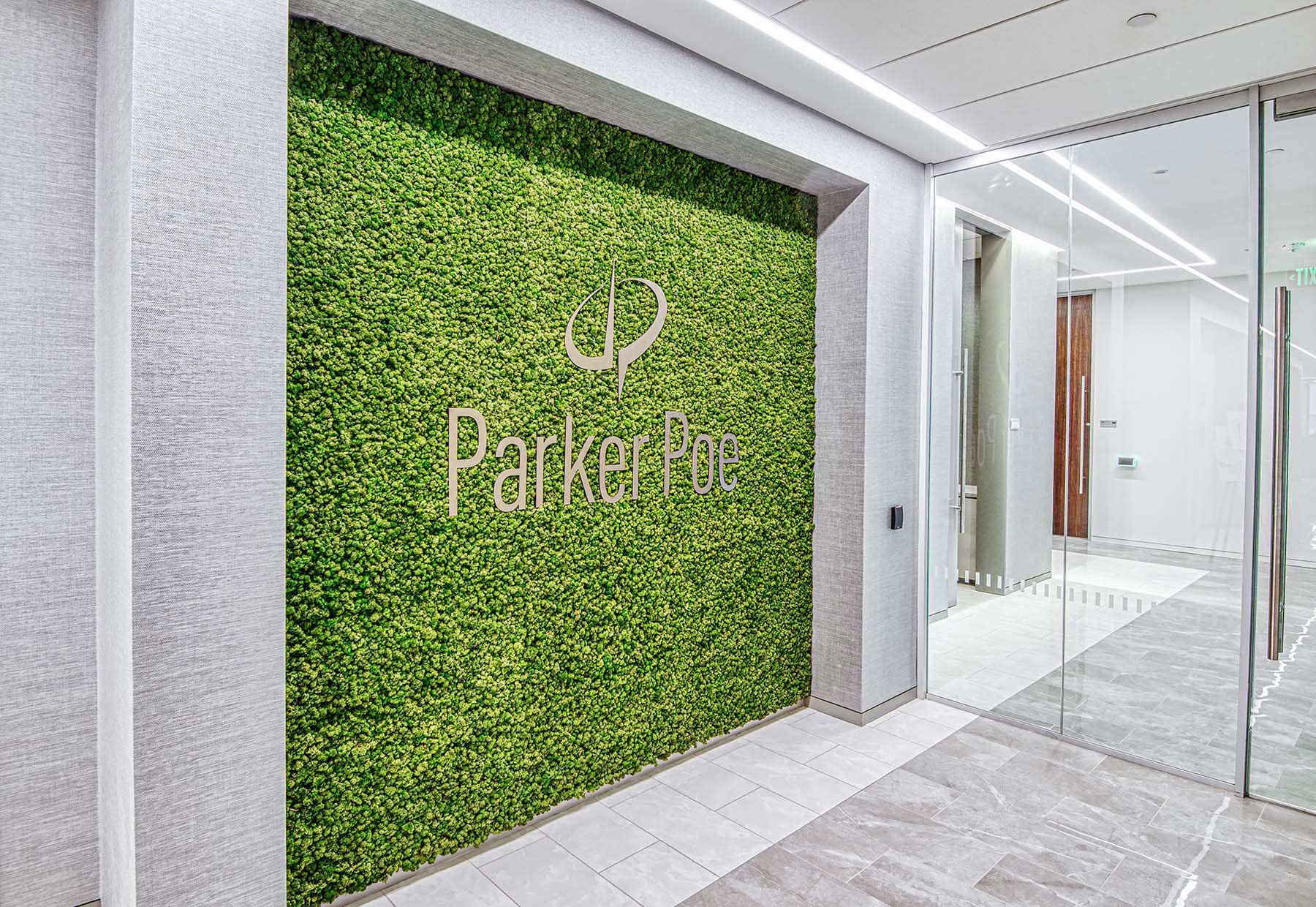 Linear lighting illuminating a green wall with Parker Poe's logo