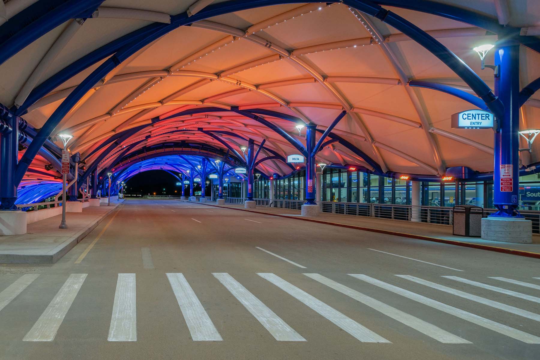 Colorful wash lighting inside an airport canopy